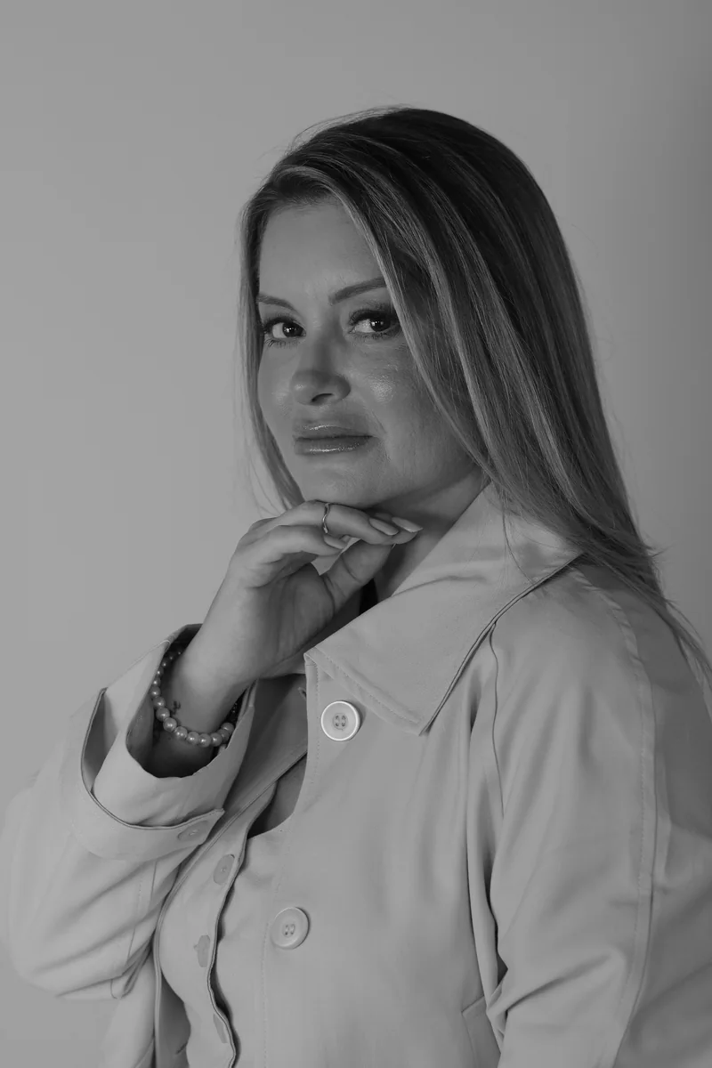Retrato em preto e branco de Jaqueline Salles com a mão apoiada sob o queixo.